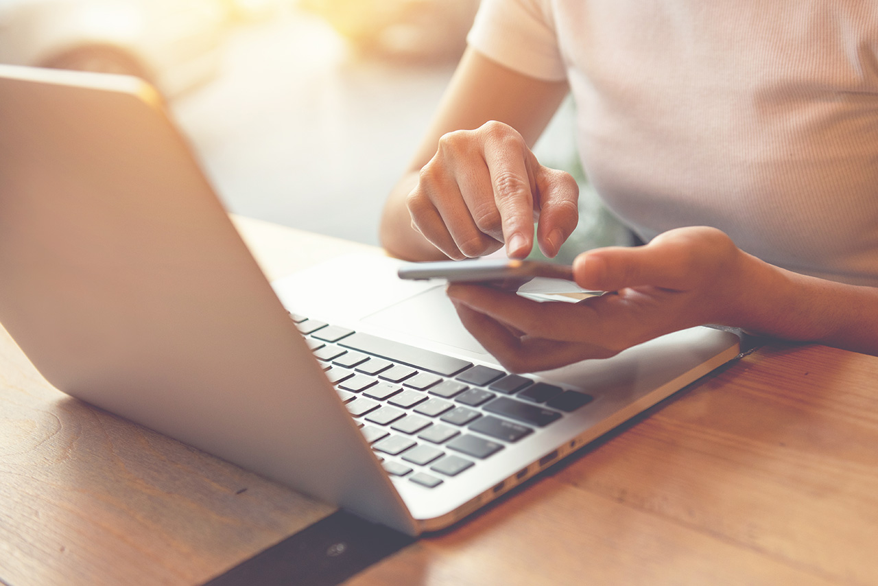 Female-using-smart-phone-and-notebook-laptop-computer
